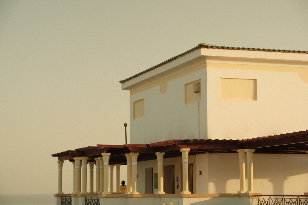 A picturesque view of a Mediterranean villa under a warm, golden sky.